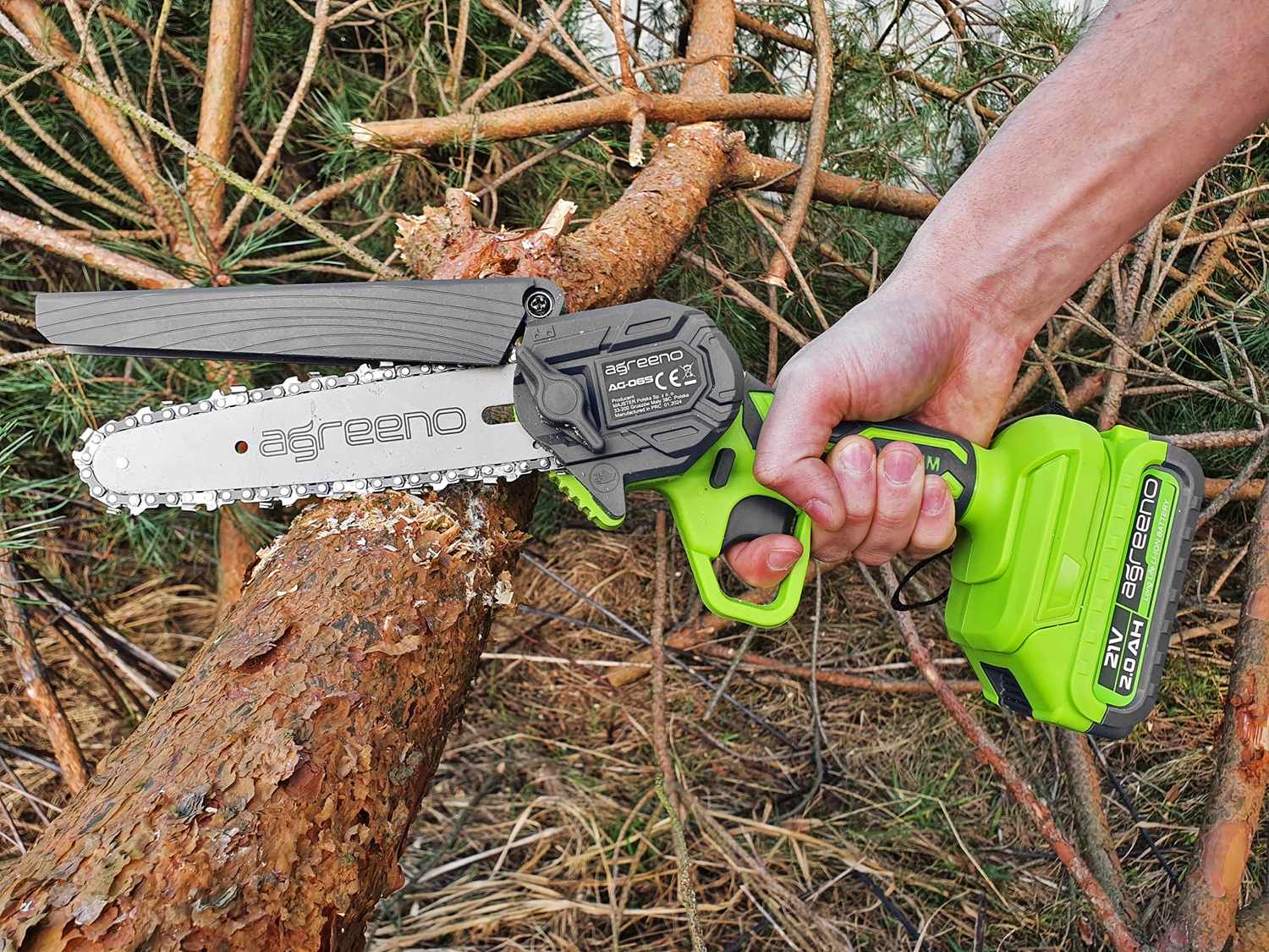 Akumulatorowa pilarka łańcuchowa marki Agreeno  w trakcie cięcia kawałka drewna - ujęcie nr 1